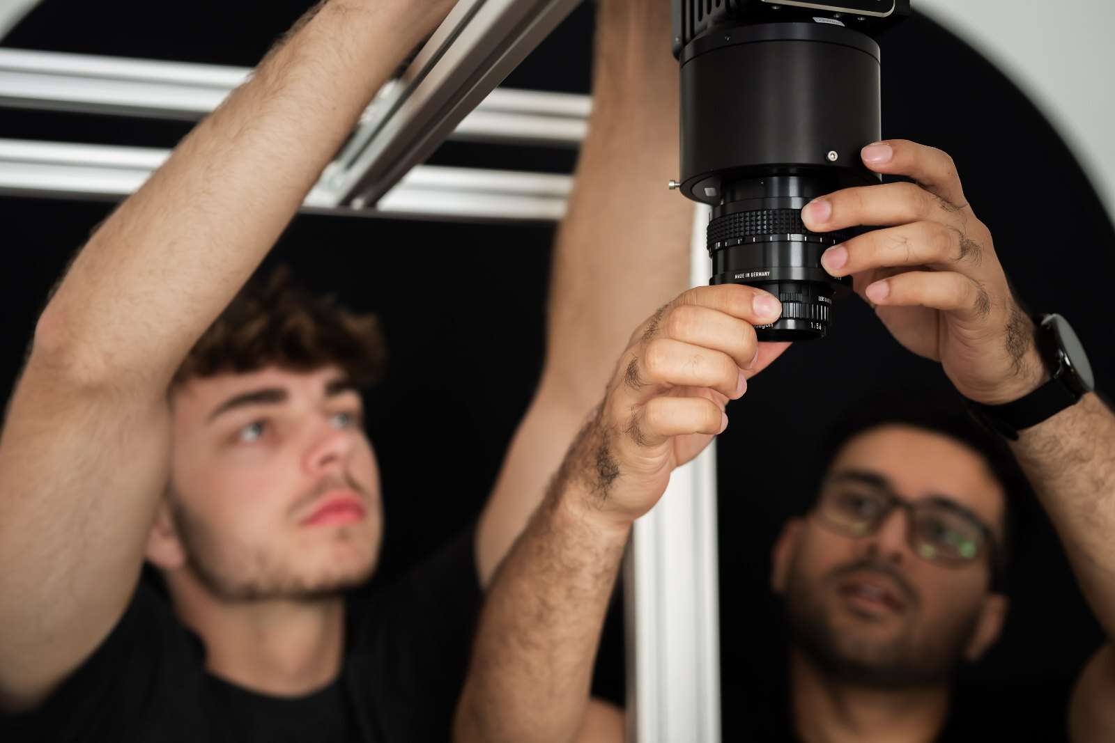 Ingenieure justieren Kamera und Objektiv am Prüfstand – Prüfstandentwicklung für automatisierte visuelle Prüfaufgaben in der Produktion