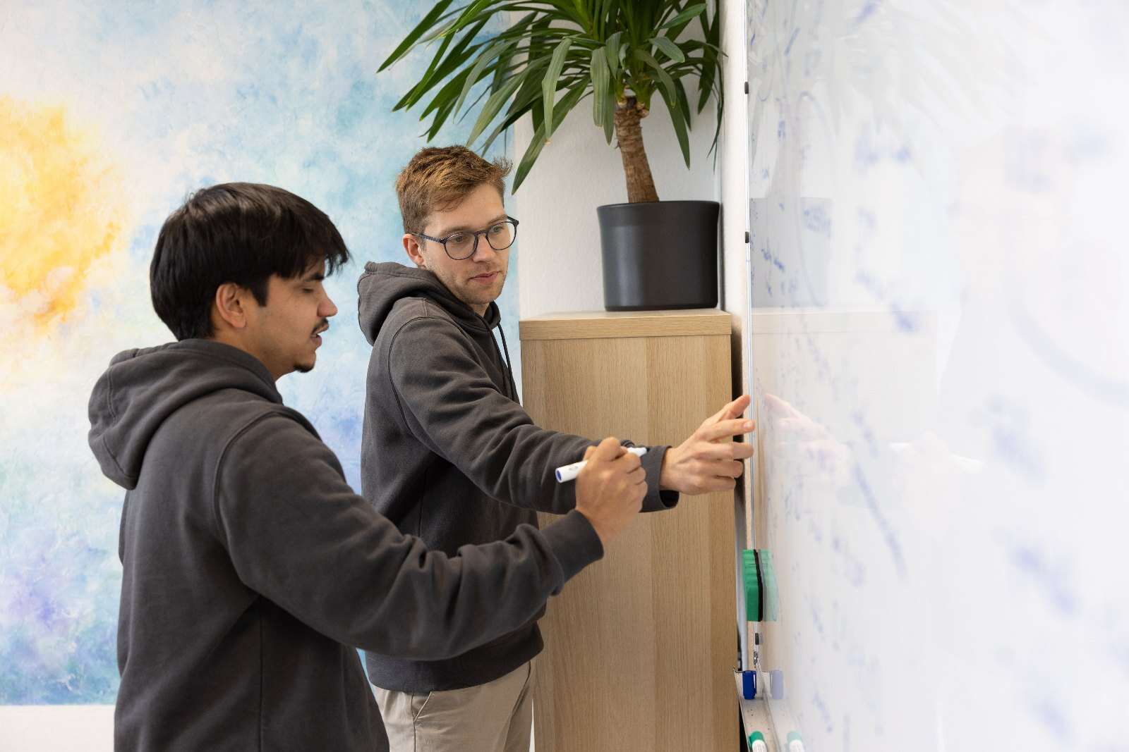 Mitarbeitende von Grünspecht Vision Labs entwerfen am Whiteboard ein Konzept für optische Inspektion und Automatisierung von Prüfprozessen
